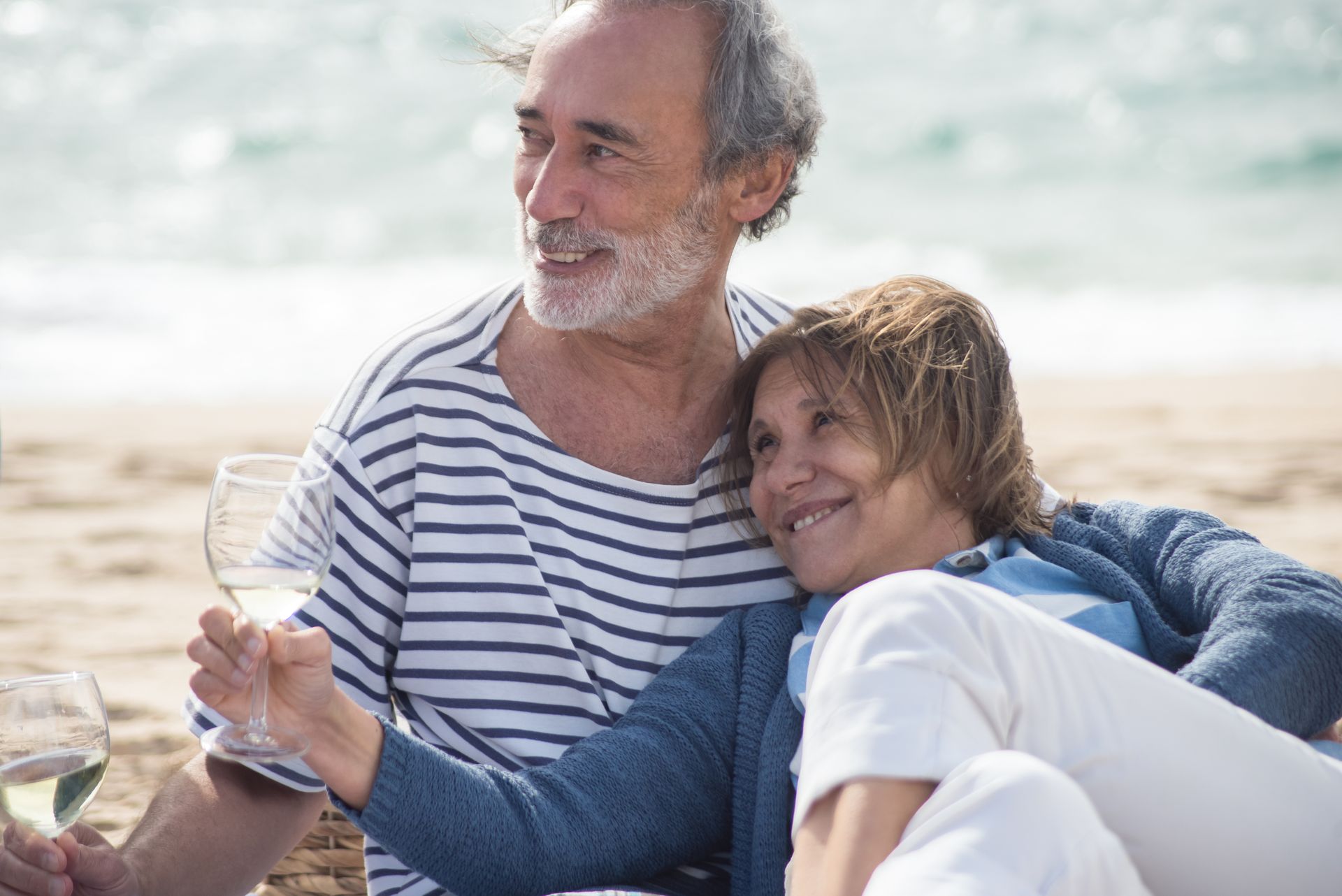 A happy mature couple relaxing together by the coast